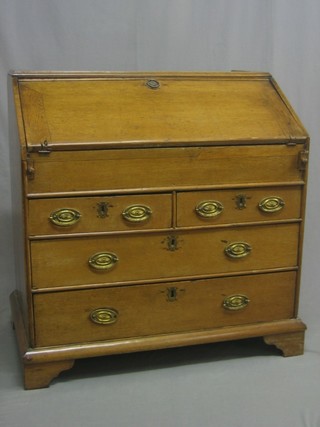 An 18th Century honey oak bureau bookcase base with fall front revealing a stepped interior, above 2 short and 2 long drawers, raised on bracket feet 36"
