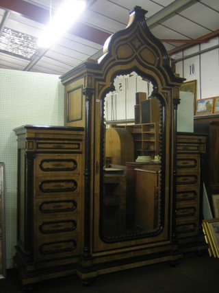 A handsome French Indian coromandel wardrobe with ebony columns, the centre section of Mirhab form enclosed by a bevelled plate mirror panelled door, flanked by a pair of chests fitted 12 drawers, raised on bun feet 89"