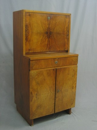 An Art Deco Continental walnut cocktail cabinet, the base fitted a drawer above a double cupboard 24"
