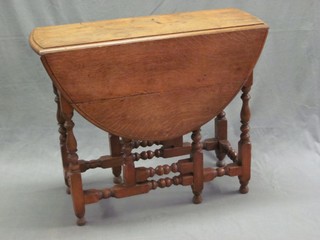 A Victorian honey oak oval drop flap gateleg tea table, raised on turned and block supports 35"