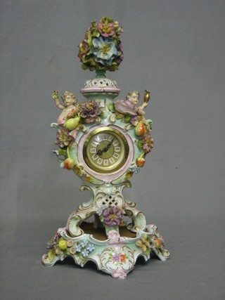 A mantel clock contained in a porcelain case supported by cherubs and with floral decoration