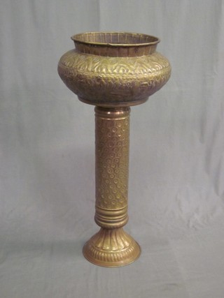 A circular Eastern embossed brass jardiniere and stand 33"