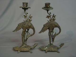 A pair of Eastern gilt metal candlesticks in the form of storks standing on turtles 12"