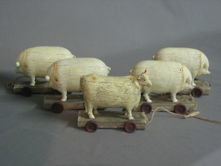 A carved resin figure of a sheep and 4 resin figures of pigs