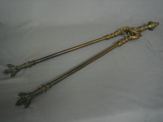 A handsome pair of 19th Century gilt metal fire tongs