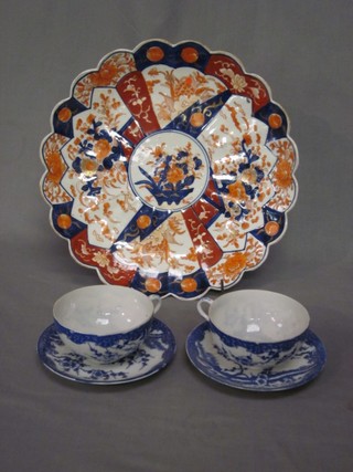 A circular Japanese Imari porcelain dish with lobed border (cracked) 12" and 2 late Japanese blue and white egg shell porcelain cups and saucers