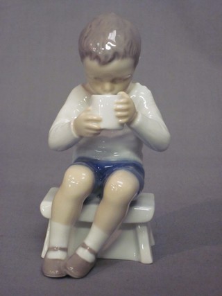 A Continental porcelain figure of a seated boy drinking a mug of tea, the base marked B and G, 5"