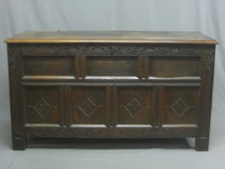 A carved oak coffer with hinged lid constructed from old timber, the front panel marked DB 1683 56"