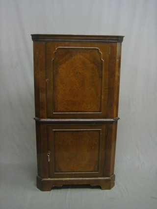 A walnut double corner cocktail cabinet with fitted interior enclosed by a panelled door, the base with cupboard enclosed by a panelled door, raised on bracket feet 29"