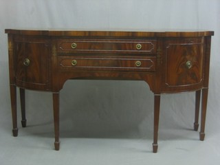 A Georgian style mahogany bow front sideboard fitted 2 long drawers flanked by a pair of cupboards, raised on square tapering supports ending in spade feet 66"