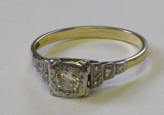 An 18ct yellow gold dress ring set a circular diamond and with 6 diamonds to the shoulders