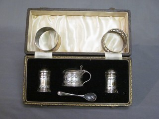 A 3 piece pierced silver condiment set with Grecian Key decoration with mustard, salt and pepper, Birmingham 1933 together with 2 napkin rings