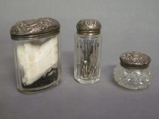 An oval glass pin jar with embossed silver lid and 2 other dressing table jars