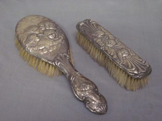 A silver backed hairbrush decorated Botticcelli angels and a do. clothes brush