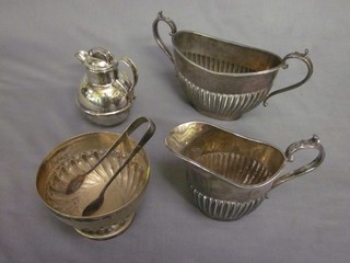 An oval Britannia metal cream jug with demi-reeded decoration, a do. sugar bowl, a circular silver plated sugar bowl and tongs and a Jersey milk canister