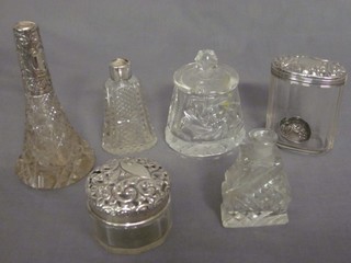 An oval cut glass pin jar with silver lid, a circular jar and cover, 3 cut glass scent bottle and a cut glass preserve jar