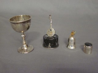A Victorian silver egg cup, a modern oval silver pill box with hardstone lid, a modern silver bell shaped pill box and a Continental silver model of a musical instrument