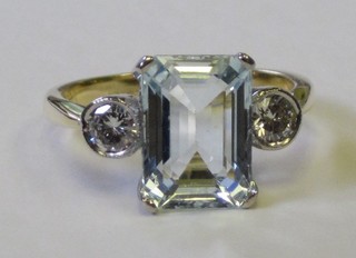 An 18ct yellow gold dress ring set a rectangular cut aquamarine supported by 2 circular cut diamonds, approx 0.40/3ct