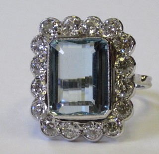 A lady's 18ct white gold dress ring set a rectangular cut aquamarine supported by numerous diamonds, approx. 2.10/7.05ct