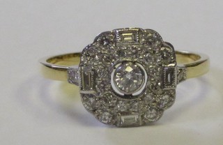 A lady's 18ct yellow gold dress ring set a circular diamond, supported by diamonds and with 4 baguette cut diamonds to the shoulders approx 0.65ct