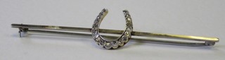 A bar brooch in the form of a horse shoe set diamonds