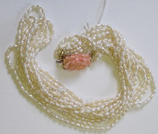 A rope of fresh water pearls with coral clasp