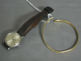 A lady's gold bangle together with a lady's Omega wristwatch contained in a stainless steel case