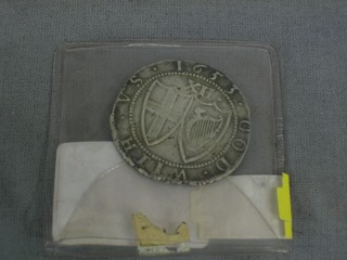 A hammered silver coin marked The Commonwealth of England, dated 1653
