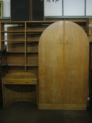 An Art Deco limed oak arch shaped wardrobe enclosed by panelled doors 40" together with a matching dressing table fitted a drawer 29"