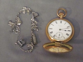 A metal charm bracelet hung numerous charms and a gold plated pocket watch contained in a full hunter case