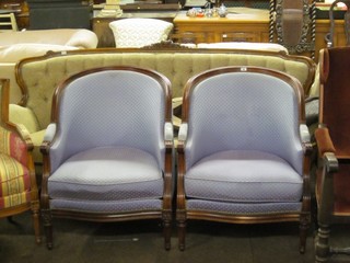A pair of mahogany show frame tub back chairs upholstered in blue material and raised on turned and fluted supports