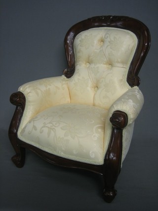 A childs Victorian style mahogany armchair upholstered in yellow buttoned material and raised on cabriole supports