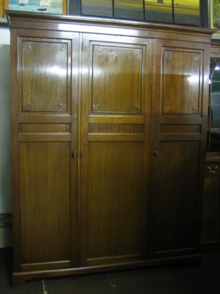 An Edwardian walnut triple wardrobe with moulded cornice and enclosed by panelled doors, the base fitted 3 cupboards 63"