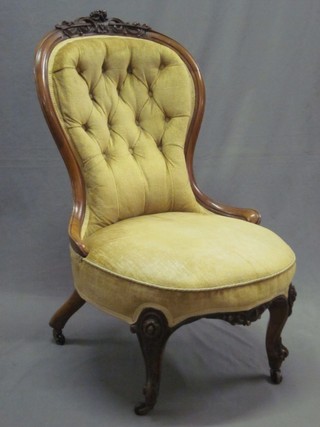 A Victorian carved walnut show frame chair with buttoned back, raised on cabriole supports