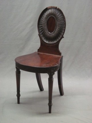 A 19th Century mahogany hall chair with carved oval back, raised on turned supports