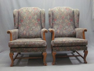 A pair of Queen Anne style walnut show frame wing chairs, raised on French cabriole supports