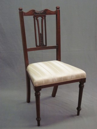 An Edwardian carved walnut stick and rail back dining chair with upholstered seat, raised on turned supports