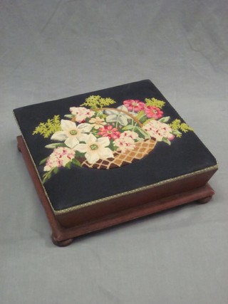 A Victorian square mahogany footstool with embroidered seat, raised on bun feet 16"