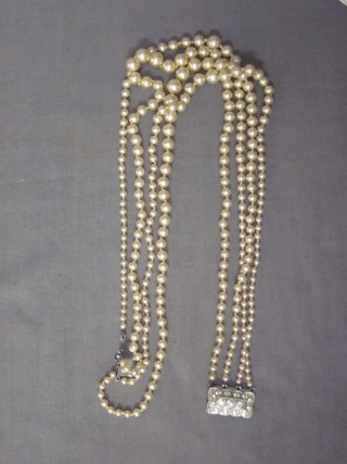 A string of simulated pearls and a pair of earrings