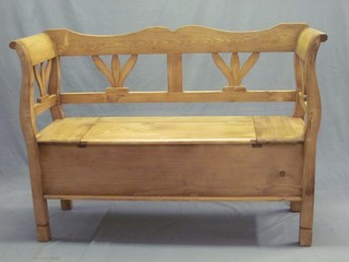 A Continental stripped and polished pine settle with hinged lid 50"