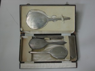 A silver backed 5 piece dressing table set comprising pair of hair brushes, clothes brush, comb and hand mirror, cased