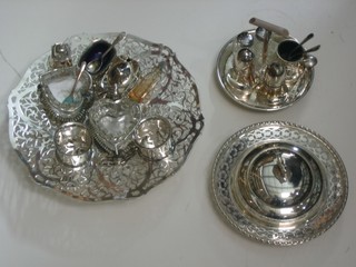 A circular pierced silver plated dish, a 3 piece silver plated condiment set with mustard, salt and pepper,  pair of heart shaped salts, 2 silver plated napkin rings, a 3 piece cruet, 2 glass pepperettes and a silver plated butter dish