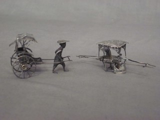 An Eastern silver model of a rickshaw and 1 other of a "sedan" chair