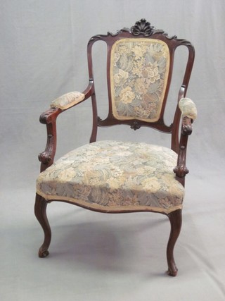 An Edwardian mahogany open arm chair, the cresting rail carved a shell and raised on cabriole supports