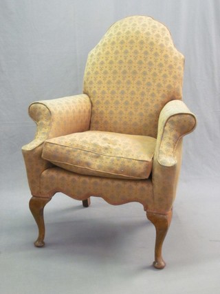 A Queen Anne style armchair raised on cabriole supports