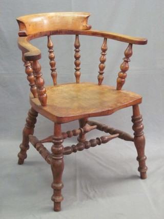 An elm Captain's chair with solid seat of serpentine outline, raised on turned supports