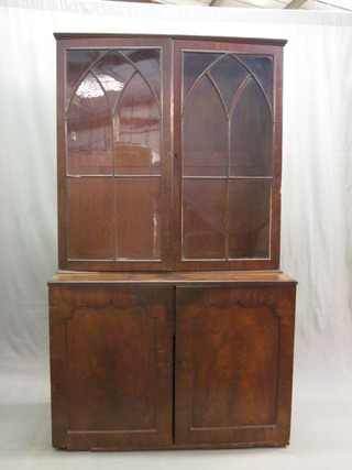 A 19th Century mahogany bookcase on cabinet, the upper section fitted adjustable shelves enclosed by astragal glazed doors, the base fitted a cupboard enclosed by a panelled door 42"
