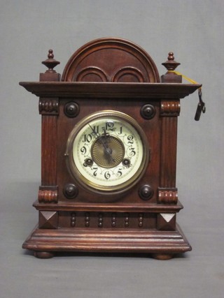 An Edwardian Continental bracket clock with enamelled dial and Arabic numerals contained in a walnut case