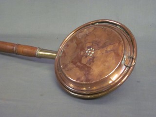 A copper warming pan with turned fruitwood handle