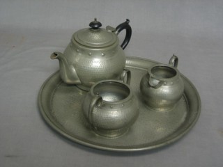 A circular planished Abbey Pewter tea tray 14" and a 3 piece Craftsman pewter teapot, comprising teapot, cream jug and sugar bowl